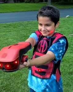 kid wearing a blue shirt with hero blast red chest cover and hand laser equipment