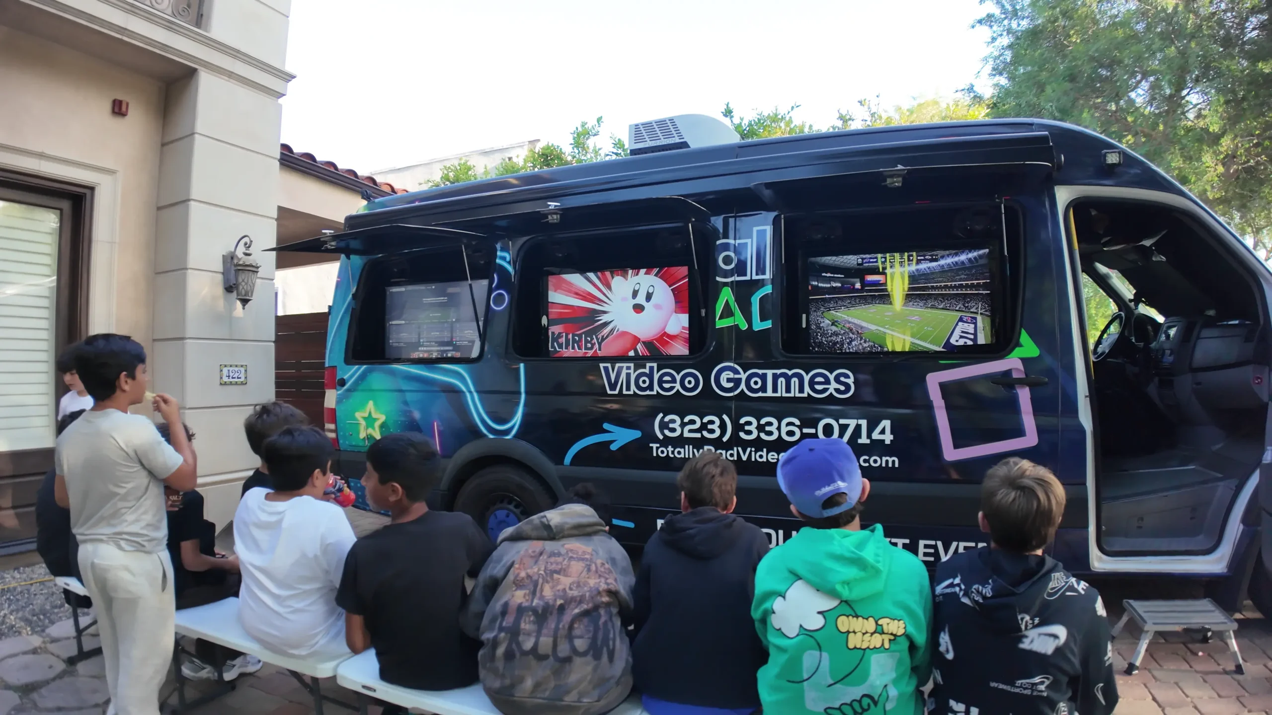 Kids playing video games outside the Totally Rad game truck