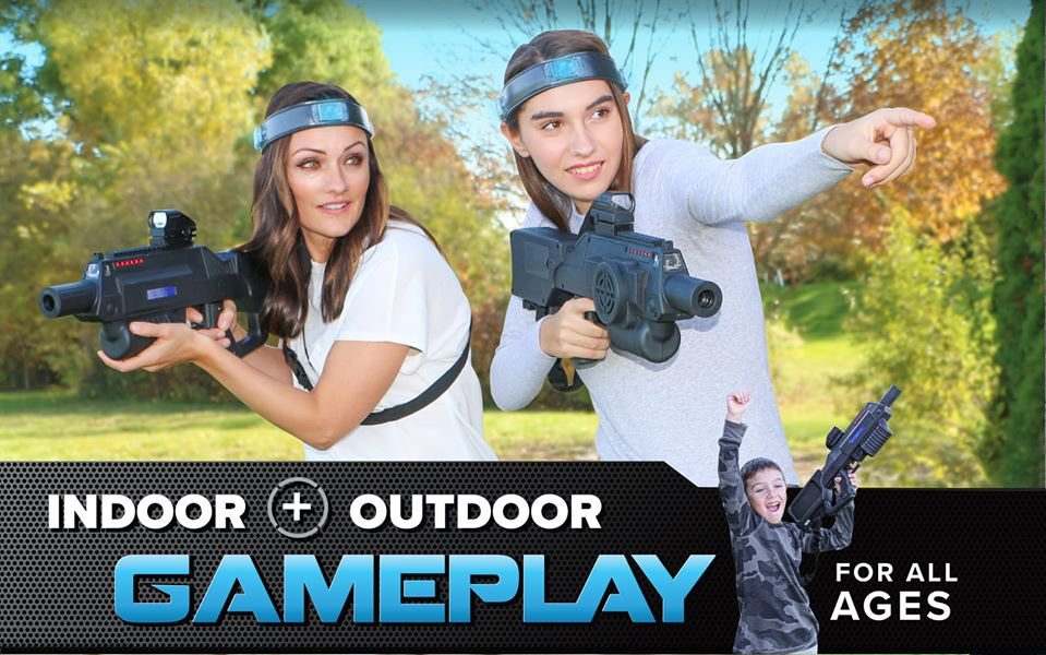 two women holding laser tags while playing outside